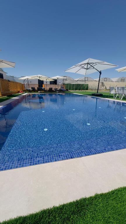 a large swimming pool with blue tiles on the ground at צימרים שדות אור in Maʼor