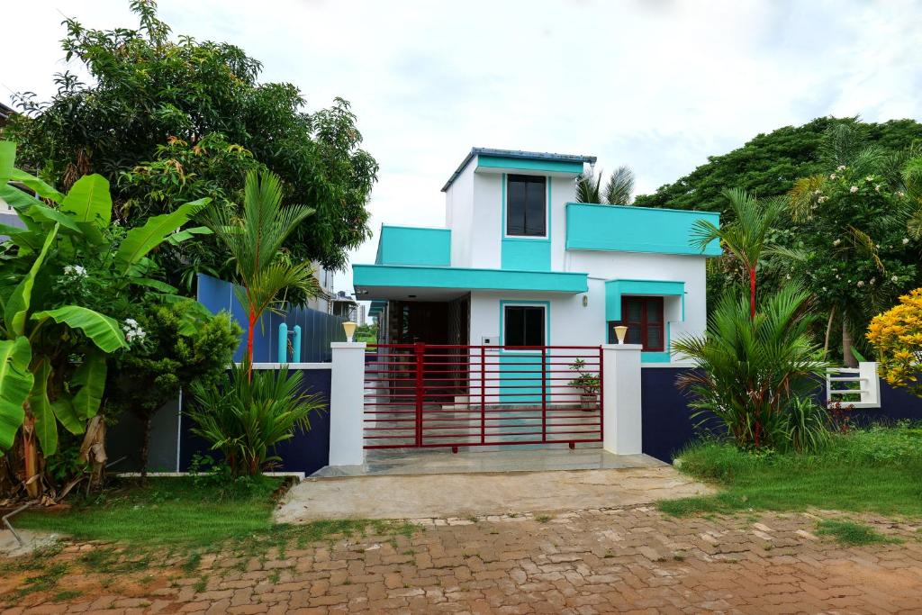 a blue and white house with a gate at Aranya Ocean Breeze in Mangalore