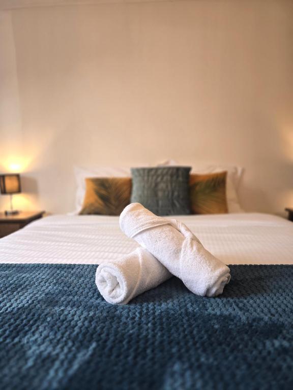 a rolled up towel sitting on a bed at LE MATIN CALME - Charme ancien - Vue canal in Dole