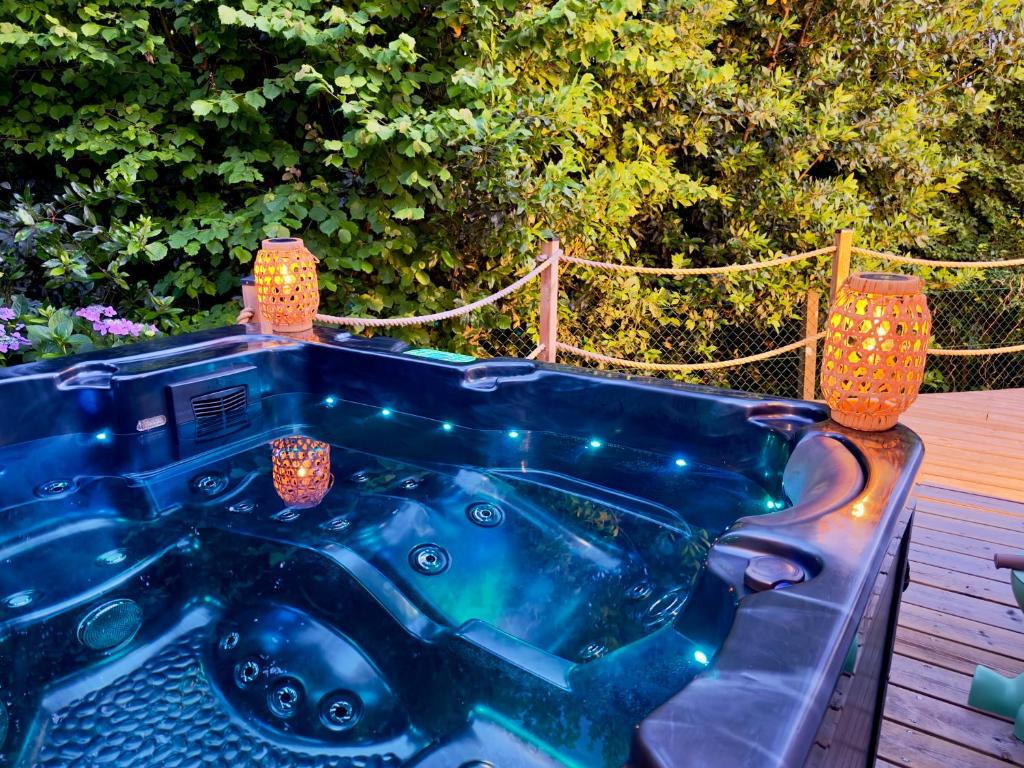 a blue bath tub sitting on a deck with lights at Maison des Chênes 64 - Spa Lodge in Boucau