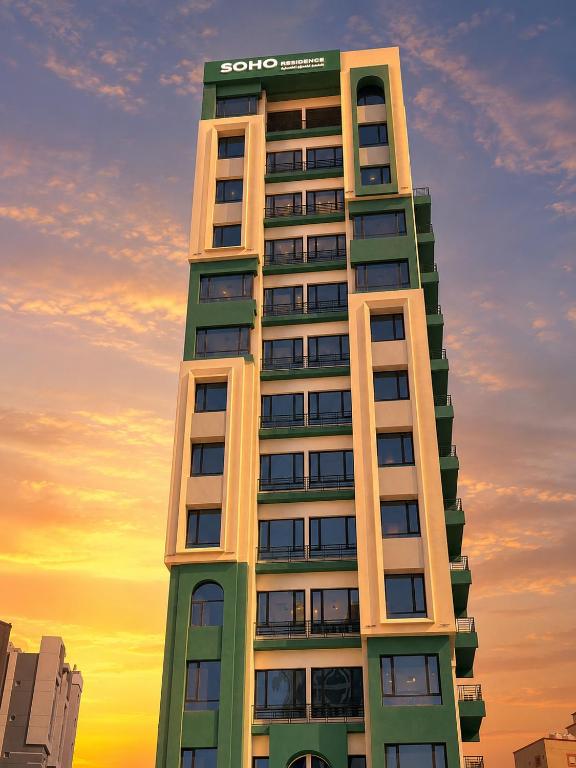 a tall building with a scoo sign on it at Soho Residence سوهو ريزيدنس in Kuwait