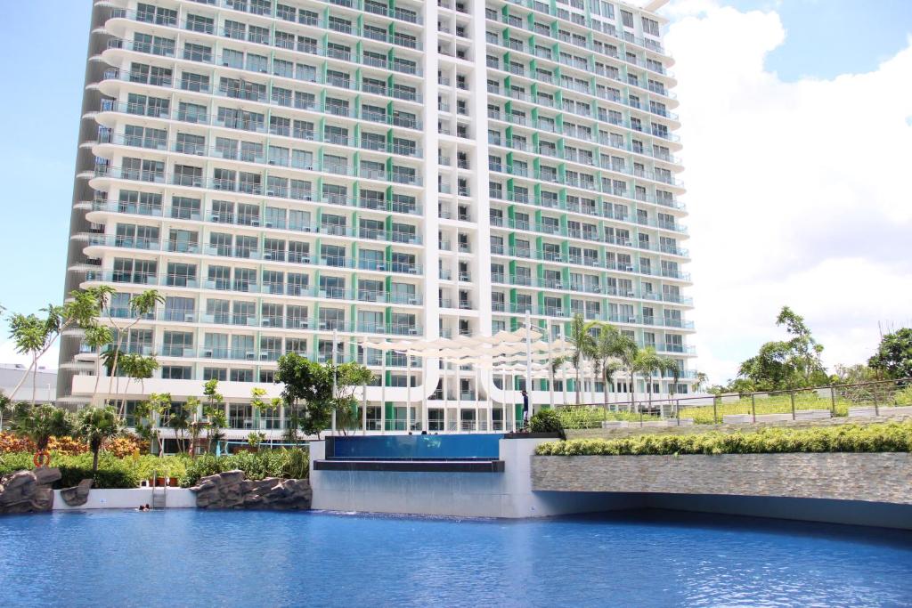 a large white building with a river in front of it at Azure Tropical Paradise in Manila