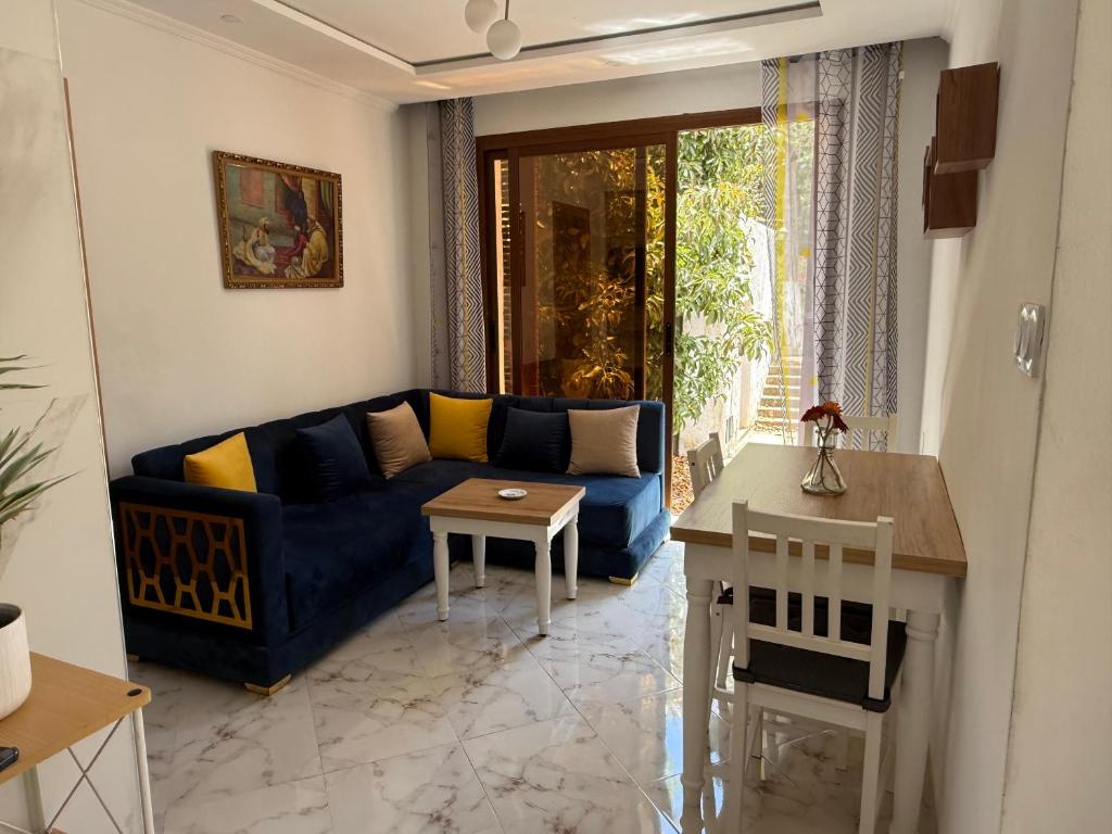 a living room with a blue couch and a table at Armonia buglaow residence MARSA MDIQ in M'diq