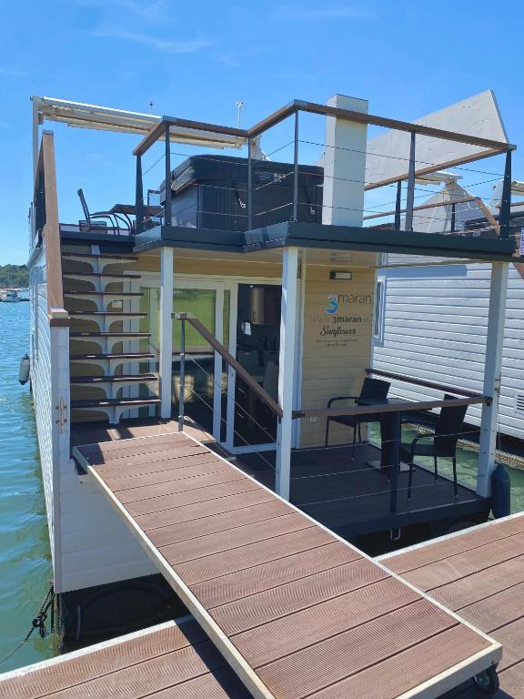 a house boat on the water with a dock at Floating house Sunflower in Pula