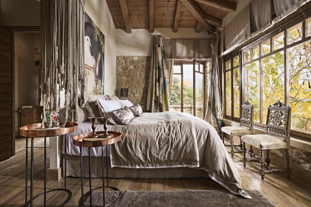 a bedroom with a bed and two tables and windows at Area Synest Nature Suites in Sinevrón