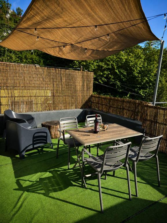 a wooden table and chairs under a large umbrella at Azorean Stays T1-Relaxing 1-Bedroom Retreat Near São Miguel Highlights in Lomba da Cruz