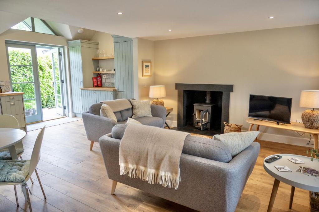 a living room with two couches and a fireplace at Riverside Cottage in Comrie