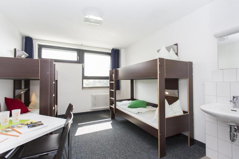 a room with two bunk beds and a sink at Jugendherberge City-Hostel Köln-Riehl in Cologne