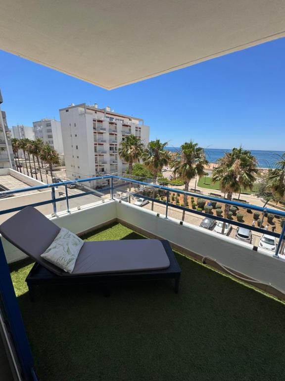 a balcony with a bed and a view of the ocean at Apartamento Deluxe AM in Quarteira