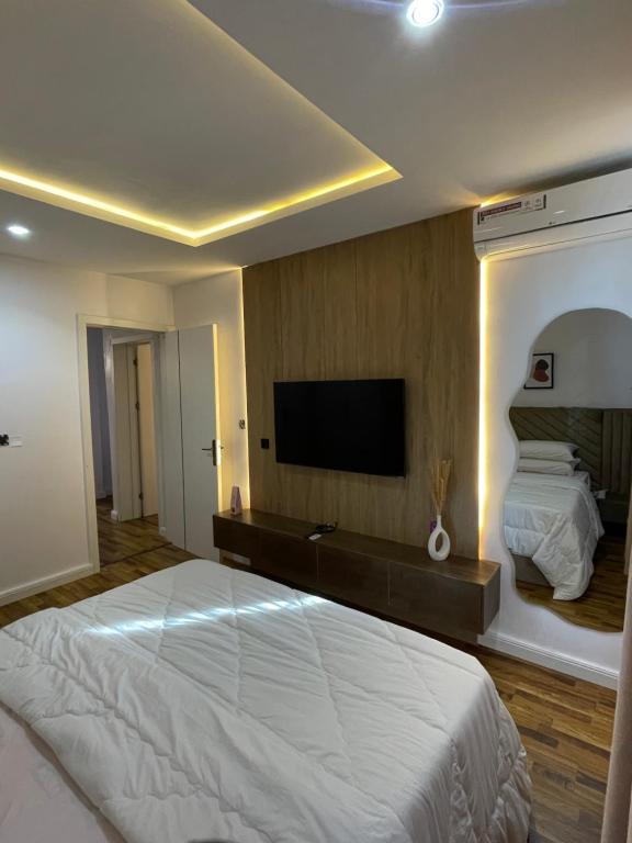 a bedroom with a large bed and a flat screen tv at Precious home apartment II in Lekki