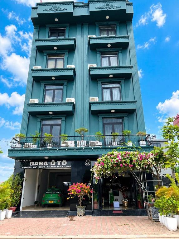 a blue building with flowers in front of it at Sky Hotel Bắc Giang in Bắc Giang