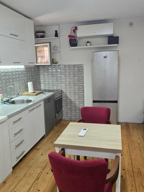 a kitchen with a table and two red chairs at Papillon in Visoko