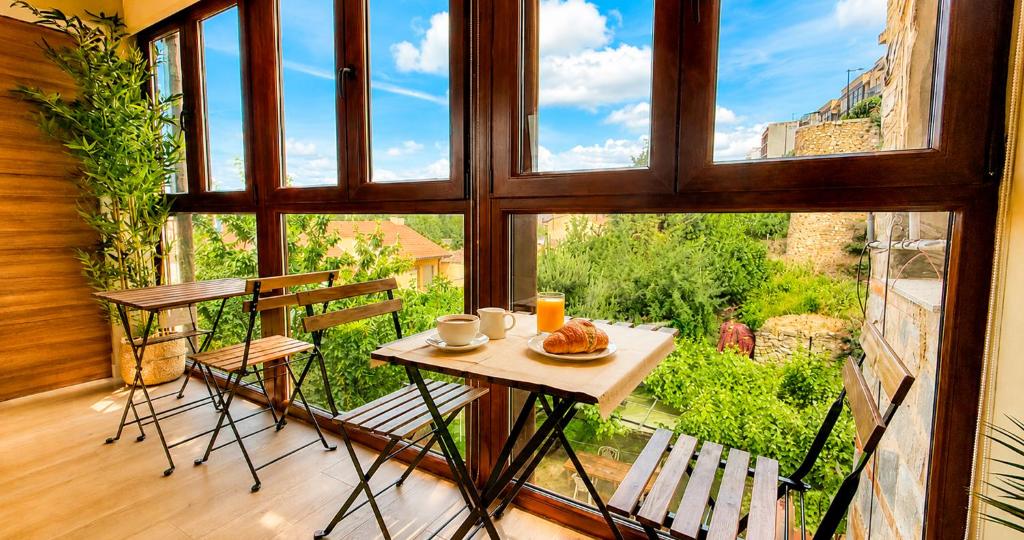 a table and chairs in a room with a large window at La Posada de las Flores in Astorga