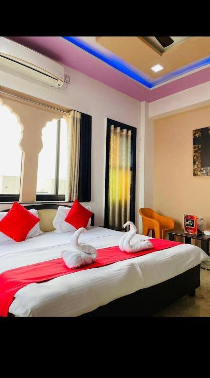 two swans sitting on a bed in a bedroom at Hotel Pratap Palace in Bharatpur