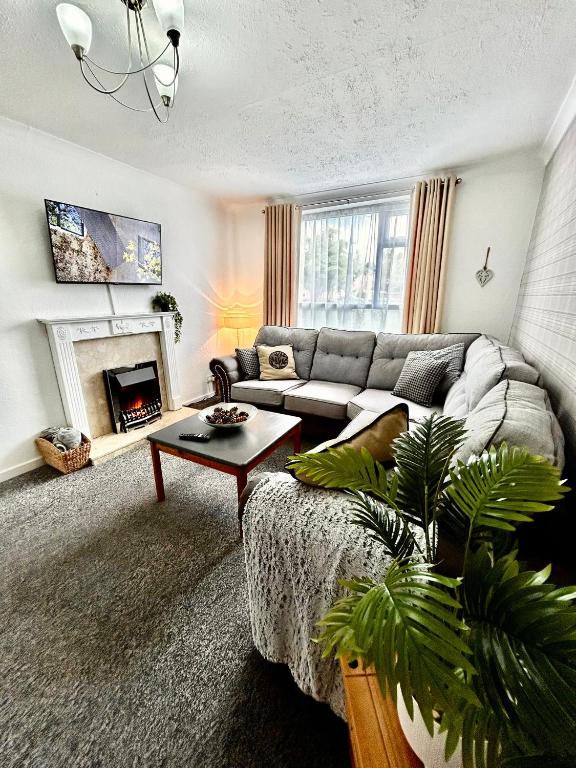 a living room with a couch and a fireplace at The Alexandria in Westhoughton