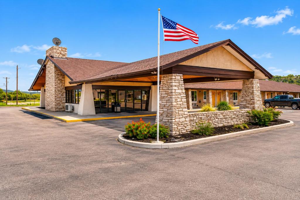 a building with an american flag in a parking lot at Segovia Lodge Junction TX I -10 in Junction