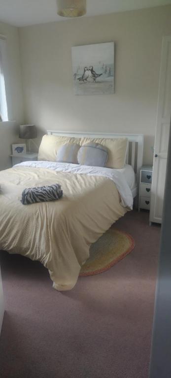 a bedroom with a large bed with white sheets and pillows at Rooms by the Lade Braes & Doocot in St Andrews in St. Andrews