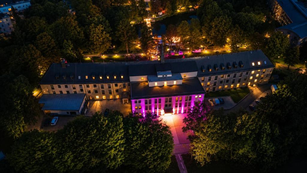 ein Gebäude mit rosa Lichtern an der Seite in der Unterkunft Pawlow History Hotel in Wolkenstein