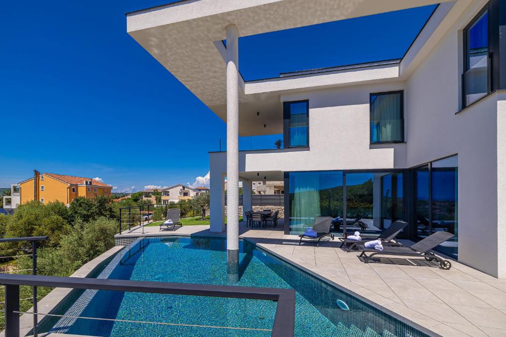 a villa with a swimming pool and a house at Luxury villa 45 with infinity pool in Punat