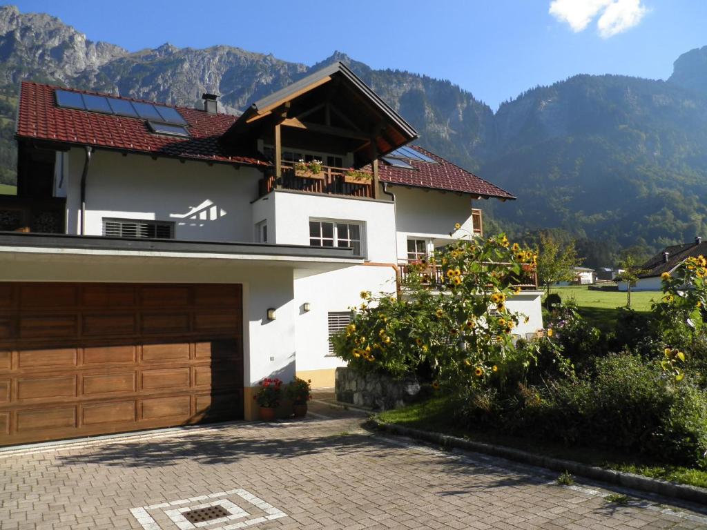 a house with a garage and mountains in the background at Familie Jäger in Innerbraz
