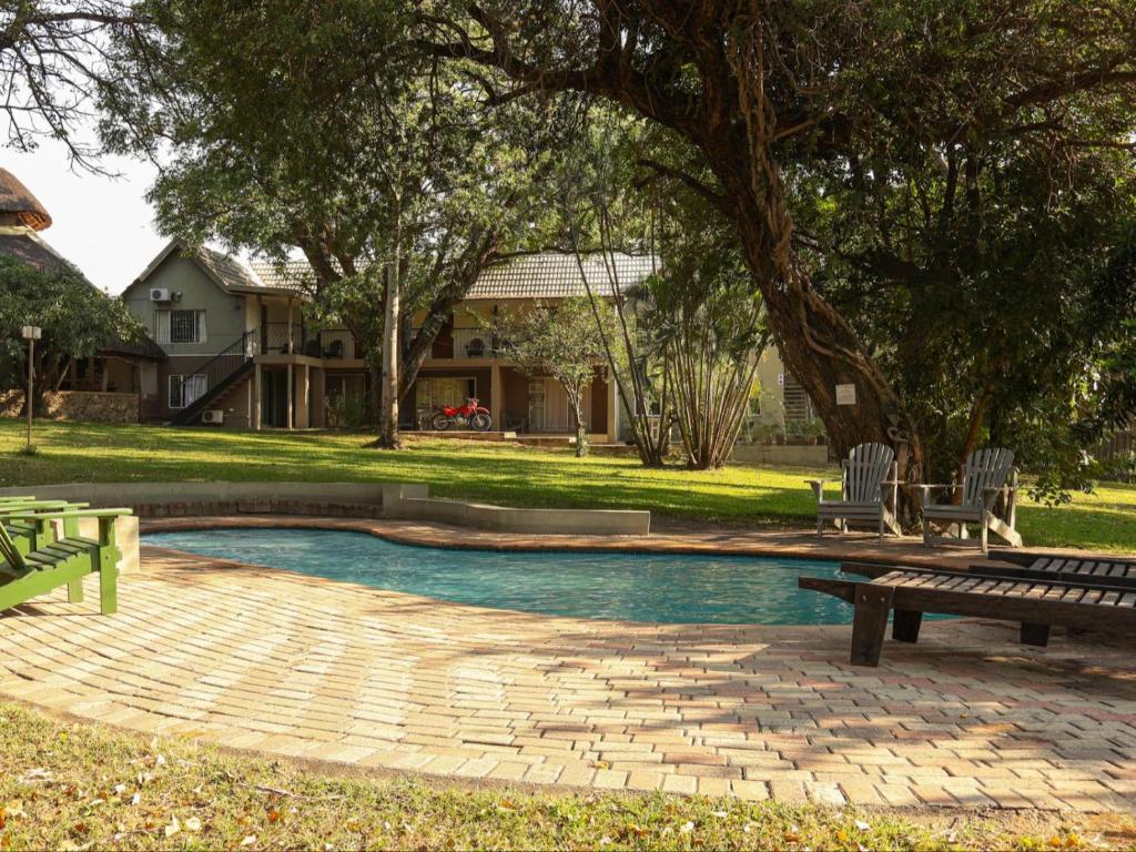 a pool with a picnic table and a bench at Kruger Foothills Lodge - Near Kruger National Park in Hoedspruit