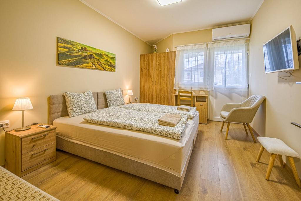 a bedroom with a bed and a desk and a chair at Palmy Home Ecser in Ecser