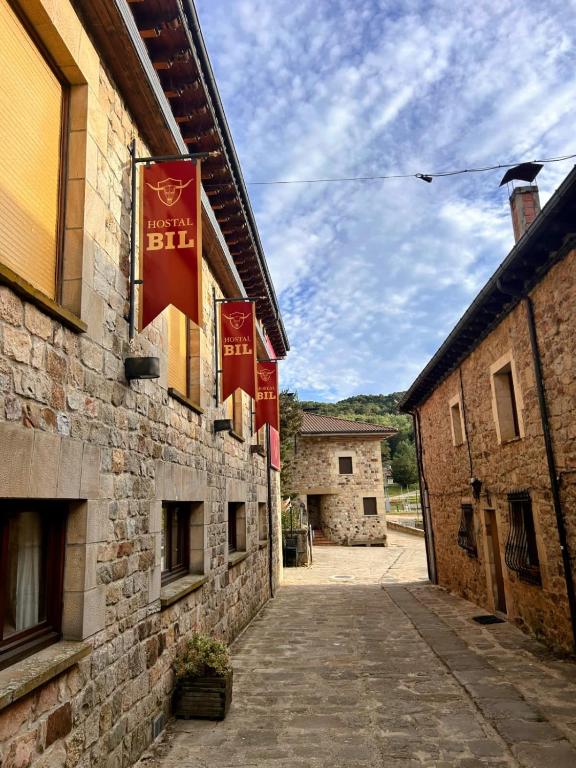an alley with red flags on the side of a building at Hostal Bil in Salduero
