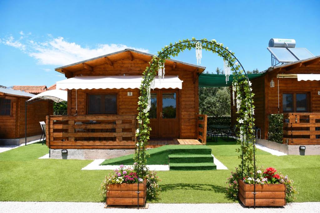 a wooden house with an arch and flowers in a yard at Kandia Woodlands in Kandia