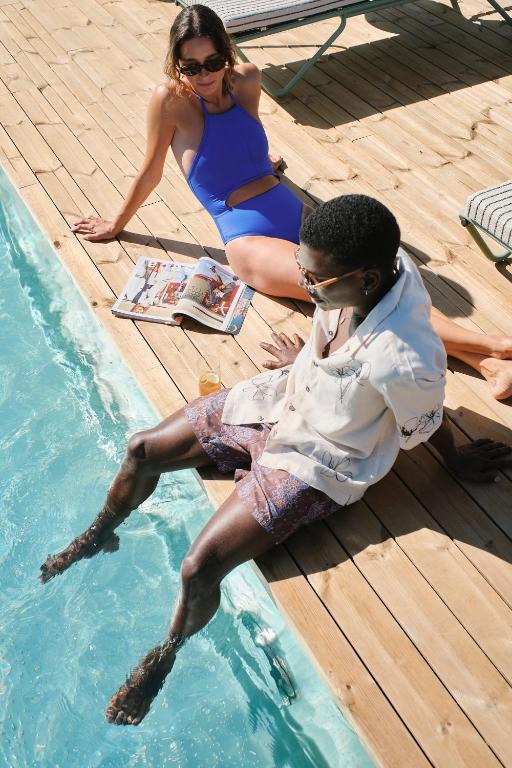 a man sitting in the water next to a woman at Terreno Barrio Hotel in Palma de Mallorca