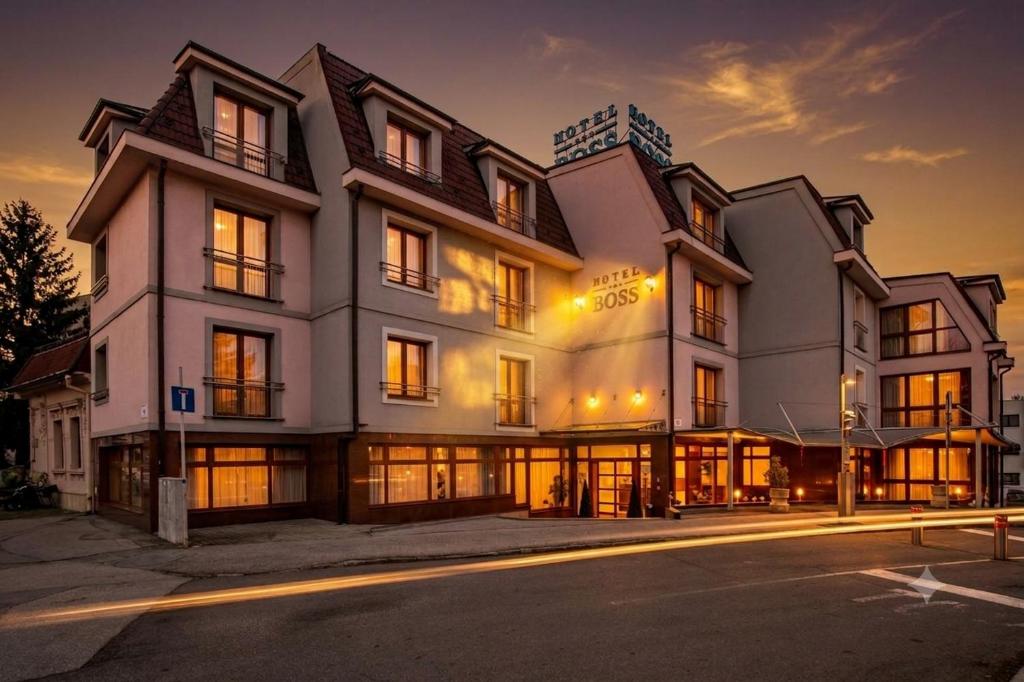 a large white building with windows at night at Hotel Boss in Žilina