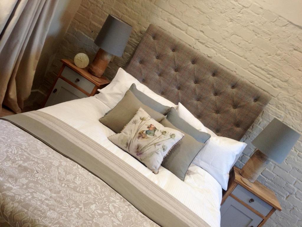 a bed with white sheets and pillows on it at Black Drove Farm in Twenty