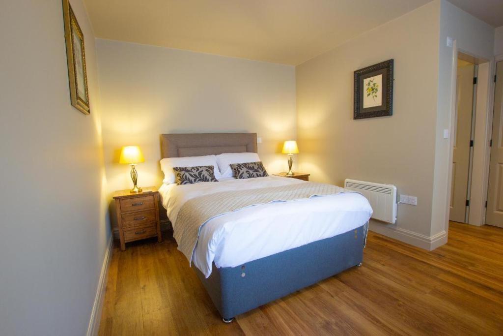 a bedroom with a large bed and two lamps at The Cherry Tree Rochford in Rochford