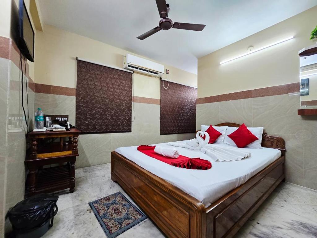 a bedroom with a bed with red and white pillows at Anandaloke Guest House in Kolkata