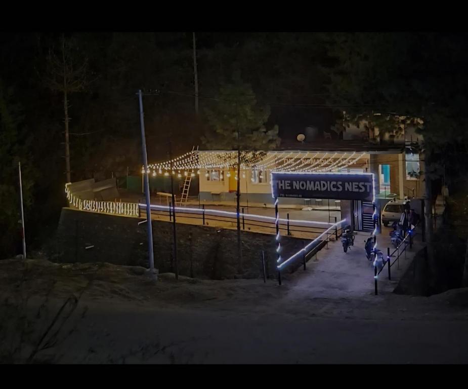 a train station at night with a sign that reads the neuromos miss at The nomadics nest in Bhadarwāh
