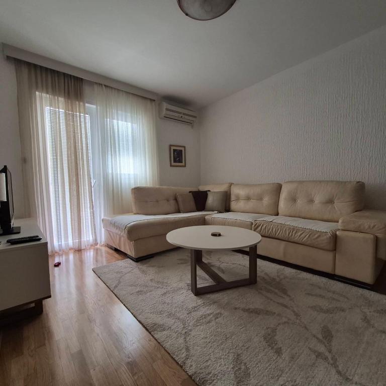 a living room with a couch and a table at Bright & Spacious Apartment Budva in Budva