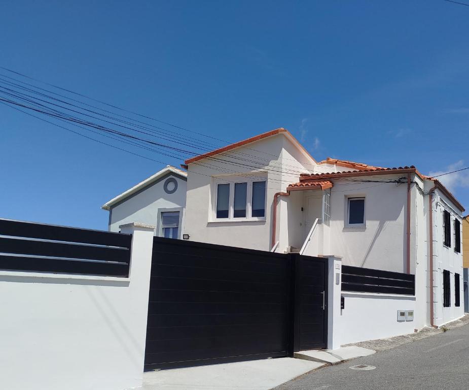 a white house with a black fence at La casa de Carmen in Neda