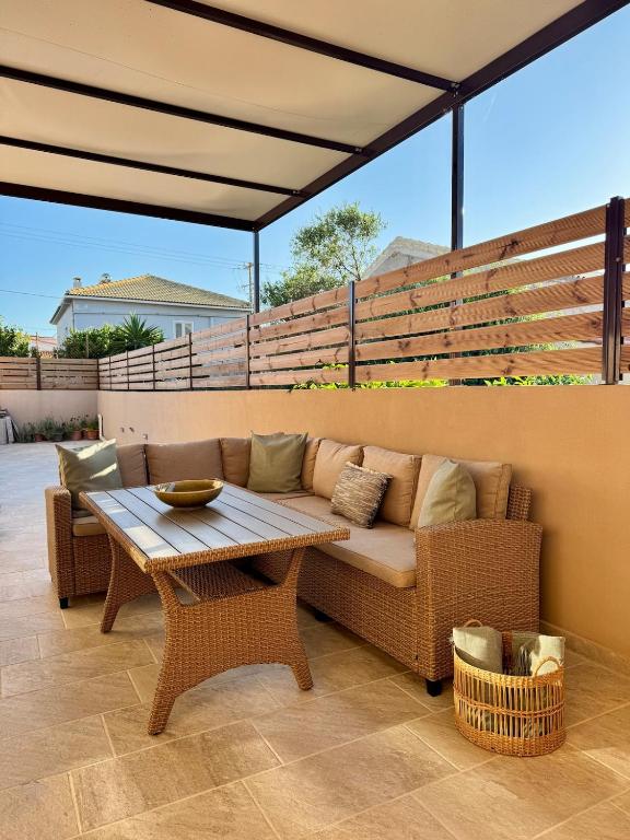 a couch and a table on a patio at Ionian Waves Villa - Marathopoli Stylish Escape in Marathopoli