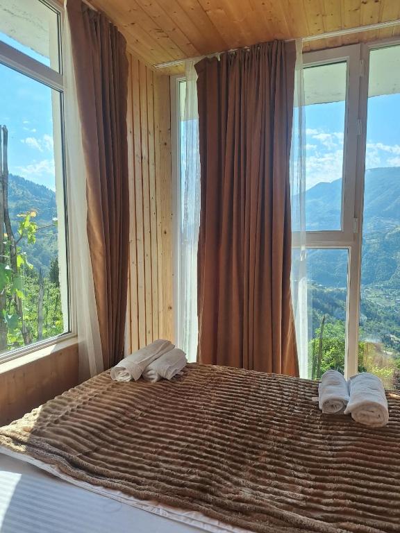 a bedroom with a bed with a large window at Akho Panorama in Batumi
