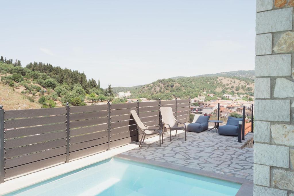 a patio with chairs and a swimming pool with a view at Lambda Luxury Villa 1 in Syvota