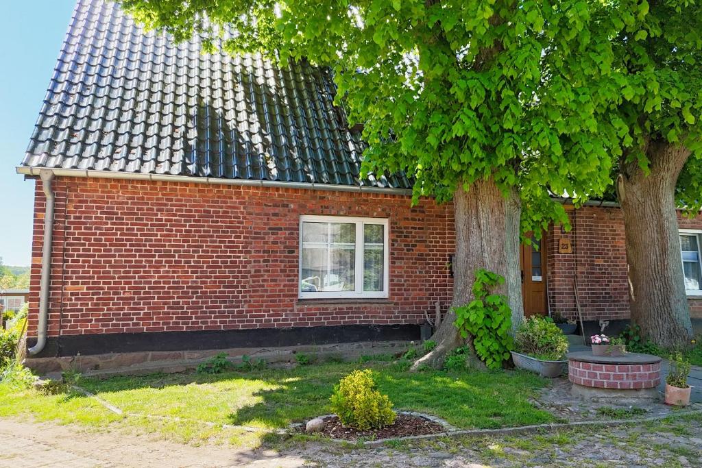 a brick house with a tree in front of it at Westphal`s Ferienwohnung in Groß Zicker
