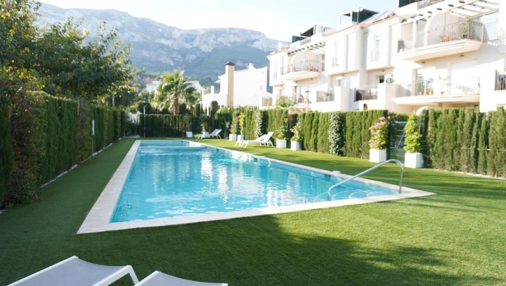 a swimming pool in a yard next to a building at Amazing apartment direct pool acces in Denia