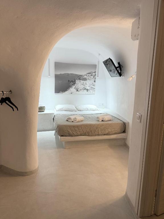 a bedroom with two beds in a white room at Fira Value Rooms- Fira Center- Capital Santorini in Fira