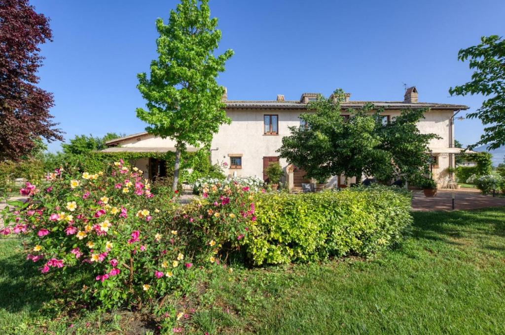 a large house with flowers in a yard at Agriturismo Il Barco in Spello