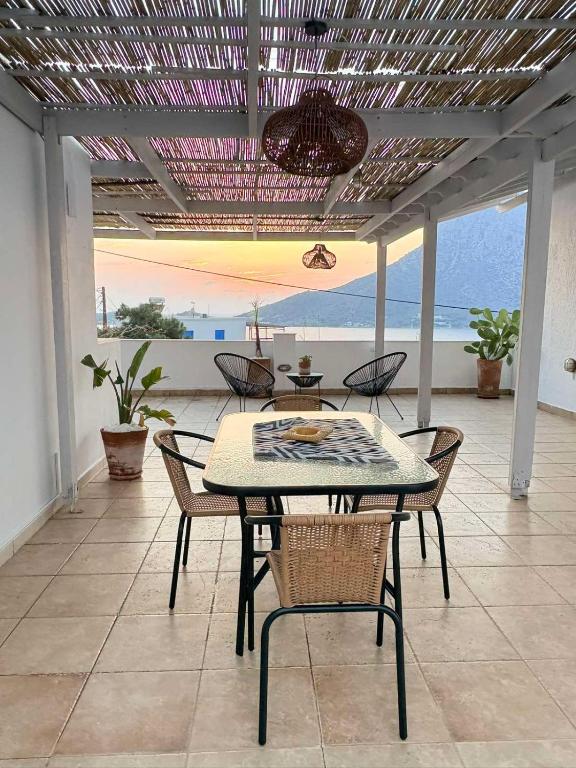 a table and chairs on a patio with a view of the ocean at Manifesto Seaview Apartment II in Kalymnos