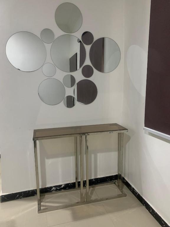 a table against a white wall with circles on the wall at Beacon Shortlet in Kaduna
