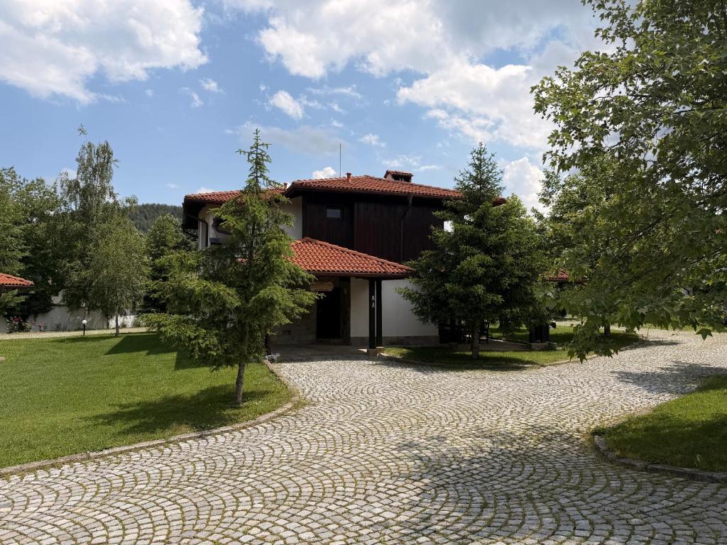 a cobblestone driveway leading to a house with a building at Марковската къща in Oreshak