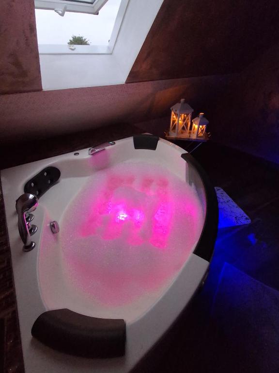 a bath tub with pink lighting in a bathroom at Leśny zakątek in Rękusy