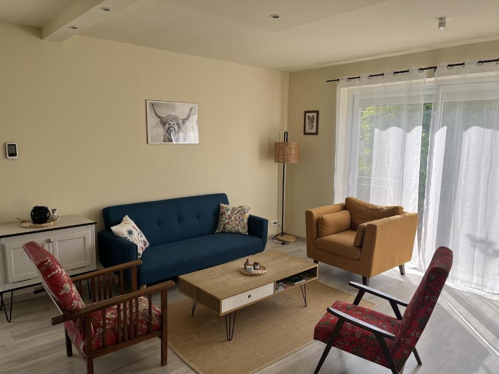 a living room with a blue couch and a chair at Gîte Chez Paddy in Ladoix Serrigny