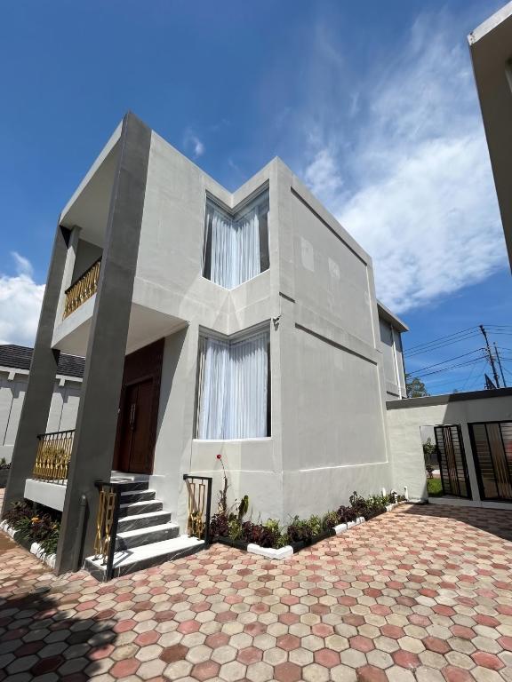 a large white house with a brick driveway at Milano Villas Puncak in Puncak