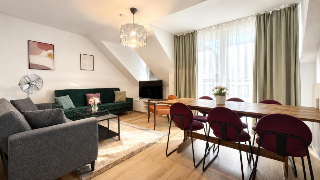 a living room with a couch and a table and chairs at URBAN FLATS Berlin in Berlin